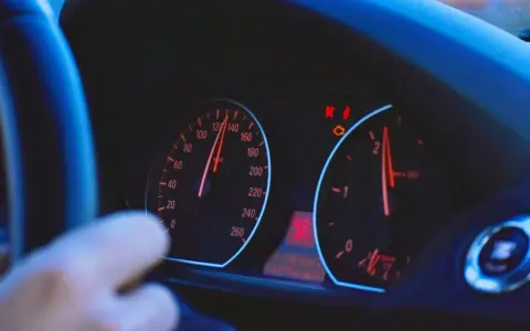 Blick auf das Armaturenbrett eines Autos. Der Tacho zeigt 120 km/h, die Drehzahl ist bei 2000 U/min. Die Tacho-Toleranz ist hierbei zu beachten.
