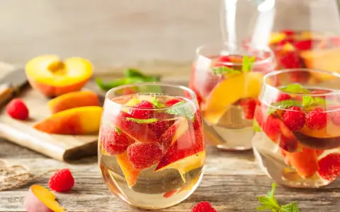 Délicieuse sangria blanche recette avec pêches, framboises et menthe fraîche. Parfait pour se rafraîchir !