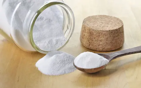 Bicarbonate de soude, une solution naturelle pour le traitement de l'oïdium. Une cuillère en bois et un pot renversé en témoignent.