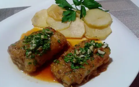 Dos trozos de bacalao a la llauna con patatas y perejil.