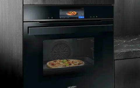 Modern ugn med touchskärm som visar en pizza. Denna Siemens studioline ugn har ångfunktion för perfekt bakning.