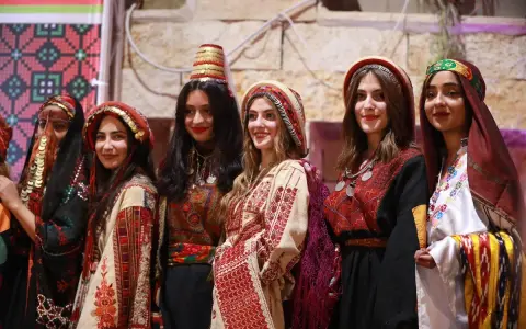 Six young women proudly showcase traditional Palestinian attire, highlighting the vibrant artistry of Palestinian designers.