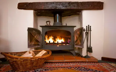 Un insert cheminée moderne, idéal pour ma prime rénov, diffuse une douce chaleur. Un panier de bois à côté promet des soirées cosy.