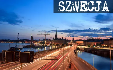 Widok na nocny Sztokholm, gdzie widać most z rozmazanymi światłami samochodów, rzekę i zabytkowe budynki. Tak wygląda Szwecja.