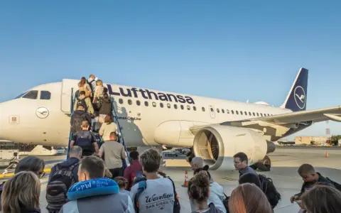 Pasażerowie wsiadają po schodkach do samolotu Lufthansa.