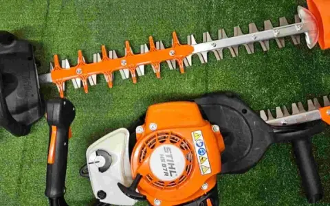 Deux taille-haies Stihl orange et noirs, prêts pour le taillage de haie.