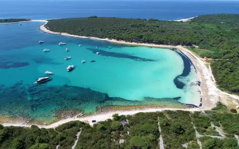 Turkusowa zatoka z łodziami, jedna z najpiękniejszych plaż w Chorwacji.