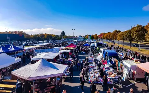 Buntes Treiben auf dem flohmarkt paderborn. Viele Stände mit Kleidung und Trödel unter blauem Himmel.
