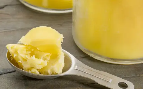 Łyżka z masłem klarowanym, czyli ghee. Zastanawiasz się, ghee co to? To złocisty tłuszcz, idealny do smażenia.