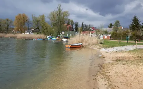 Spokojna tafla wody, łodzie przy brzegu i piasek tworzą malowniczy krajobraz. Czy to najczystsze jezioro w Polsce?