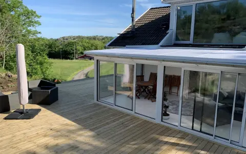Ny slipad altan med glasveranda och utemöbler. Perfekt för att njuta av sommaren.