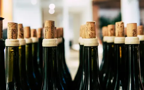 Rzędy butelek z korkami, gotowe na degustację. Każdy korek to obietnica smaku, jak wino wytrawne po włosku.