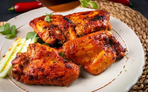 Saftige Hähnchenflügel, perfekt gegrillt, ein köstliches pollo fino rezept. Garniert mit frischer Petersilie und knackigem Sellerie.