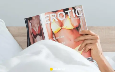 Mężczyzna w łóżku czyta magazyn "Erotic", przygotowując się do masturbacji przed seksem.