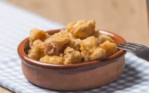 Tazón de fritura de pescado crujiente, listo para disfrutar con un tenedor.
