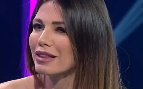 Federica Masolin, con un sorriso accennato, sembra pensare al suo fidanzato mentre parla in TV.