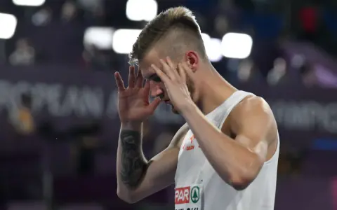 Norbert Kobielski, lekkoatleta, zamyka oczy, skupiając się przed ważnym startem.