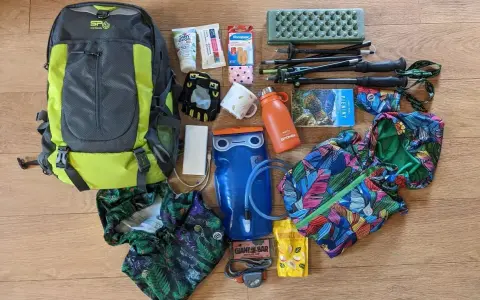 Plecak, kijki trekkingowe, bukłak, kurtka i inne akcesoria gotowe na wyjazd w góry.
