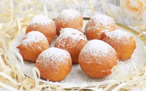 Puszyste paczki z serka homo, posypane cukrem pudrem, kuszą swoim wyglądem. Idealne na deser lub słodką przekąskę.