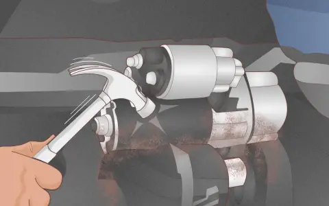 A hand uses a hammer to tap a car's starter motor, a common trick for how to start a car with a bad starter.