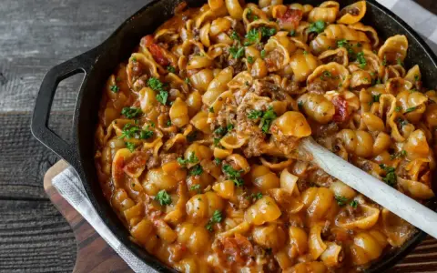 Herzhaftes Nudelgericht mit Hackfleisch in cremiger Sauce, ein Beispiel für schnelle Fleischgerichte, garniert mit Petersilie.