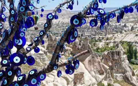 Ein Baum voller blauer Glasaugen, die wie ein arabisches Auge vor der Felslandschaft von Kappadokien schützen.