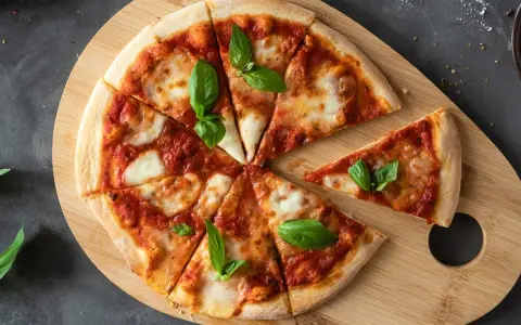 Margherita na desce z drewna. Proste ciasto na pizzę zawsze wychodzi, ozdobione pomidorami, mozzarellą i bazylią.