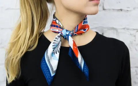 Elegancka gawroszka jak nosić? Wzorzysty apaszek z motywem Londynu zawiązany na szyi, dodaje uroku stylizacji.