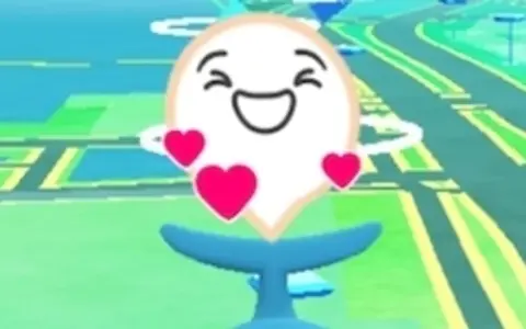 Szczęśliwy pokemon go buddy, otoczony serduszkami, wesoło macha ogonem na tle mapy gry.