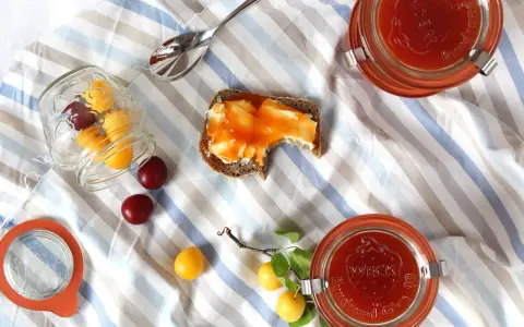 Kriecherl-Marmelade auf Brot, Gläser und frische Früchte. Perfekt für leckere Kriecherl Rezepte.