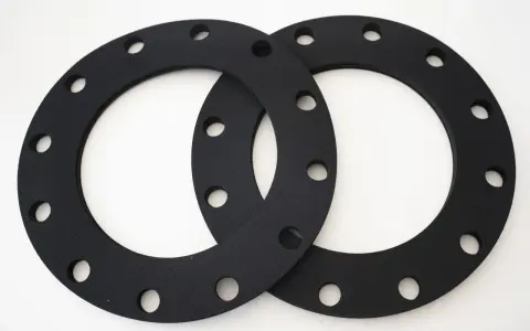 Deux joints sbr noirs, circulaires et percés, prêts à assurer l'étanchéité d'une connexion.
