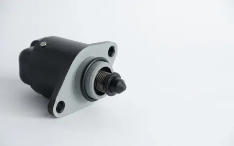 A black and gray idle air control valve, a common cause of rough idling symptoms.
