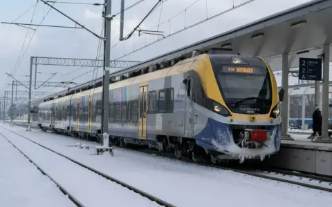 Pociąg EN78A-008 B relacji R34 Katowice stoi na zaśnieżonym peronie. Podróżuj taniej z bliskimi, wybierając kolej.