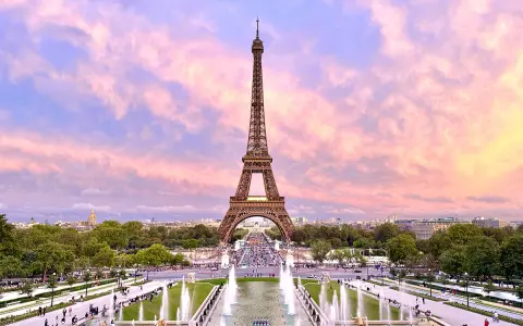 Eiffelturm im Abendrot, ein Muss, wenn man in Paris ist. Brunnen und Menschen beleben die Szenerie.