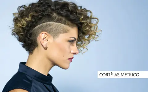 Mujer con pelo corto rizado y rapado asimétrico, luciendo un estilo audaz y moderno.