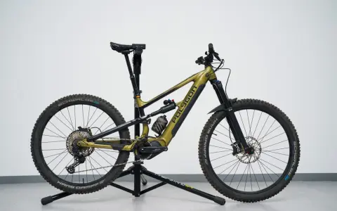 A gold Polygon mullet bike with a dropper post, full suspension, and knobby tires, ready for any trail.