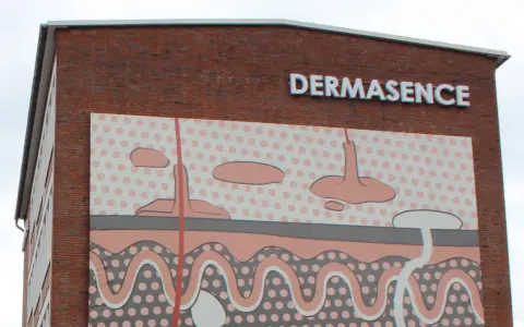Gebäude mit Schriftzug DERMASENCE und einer Hautschichten-Grafik.