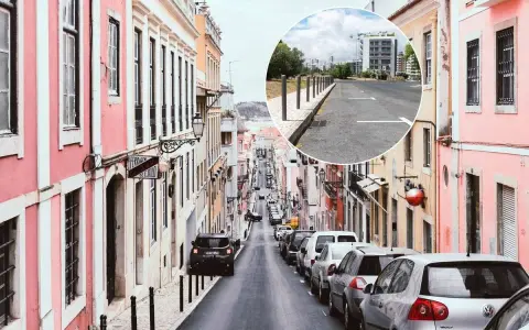 Bunte Häuser säumen eine steile Straße in Lissabon. Ein Kreis zeigt einen Parkplatz mit Markierungen, der eine Option für Parken Lissabon darstellt.