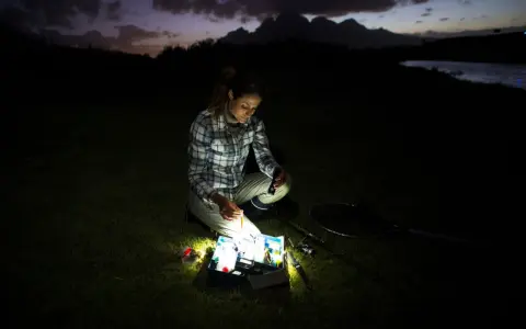 Kobieta przygotowuje się do nocnego łowienia. Czy 800 lumenów to dużo, by zobaczyć przynęty w ciemności?