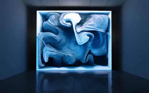 Une oeuvre d'art numérique captivante, aux formes bleutées et texturées, évoquant un nuage ou une vague figée dans un cube lumineux.