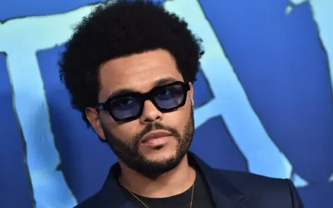 The Weeknd w okularach, z afro i zarostem, na niebieskim tle. Pośpiesz się jutro, bo to jego premiera!