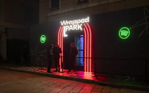 Ingresso neon per il Spotify Wrapped Park, con persone in attesa.