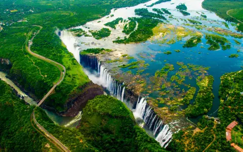 Wodospad Wiktorii, jedna z największych atrakcji Zimbabwe, z lotu ptaka. Potężny nurt rzeki Zambezi spada kaskadami w dół, tworząc mgłę i tęczę.