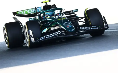 Un coche Aston Martin Honda verde compite en la pista, con el logo de Aramco en el alerón.