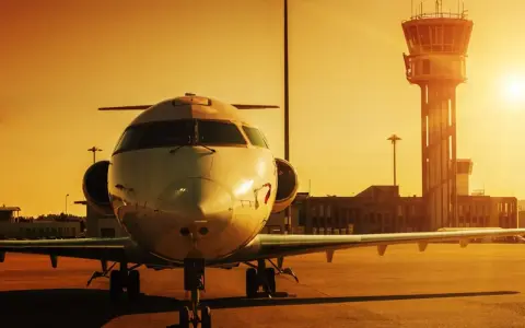 Ett privatjet står parkerat på en flygplats på Cypern vid solnedgången, med kontrolltornet i bakgrunden.