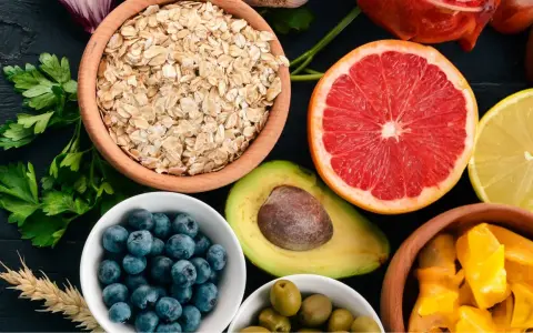 Assortiment de fruits et légumes : flocons d'avoine, myrtilles, avocat, pamplemousse, citron, olives, mangue. Attention aux aliments mauvais pour la flore intestinale.
