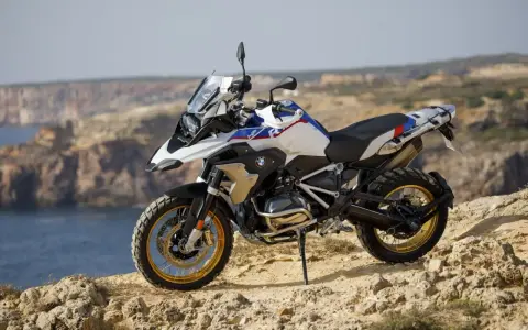 Moto BMW lista para aventuras en trail asfalticas, con vistas al mar y acantilados.