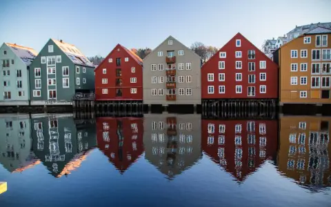 Kolorowe domy nad wodą, odbijające się w spokojnej tafli. Idealne miejsce na pracę z norweskim, podziwiając architekturę.