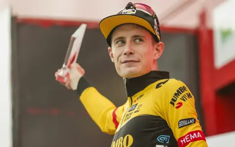 Jonas Vingegaard, strahlend mit einer Trophäe, trägt sein gelbes Jumbo-Visma Trikot.