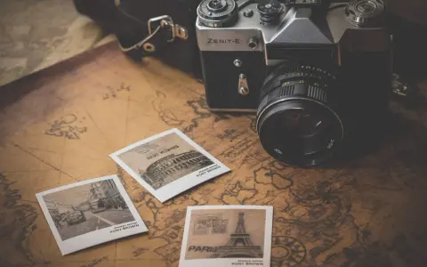 Stara kamera Zenit-E, mapy i pocztówki z podróży. Idealny zestaw do fotografii poradnikowej, by uchwycić wspomnienia.